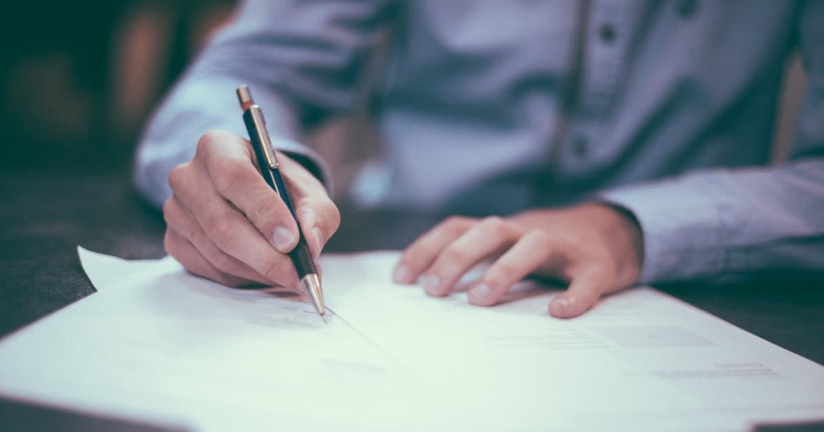 Iemand die een document tekent. De verplichtingen uit de AI Act volgen het gebruik van het systeem, niet de factuur.
