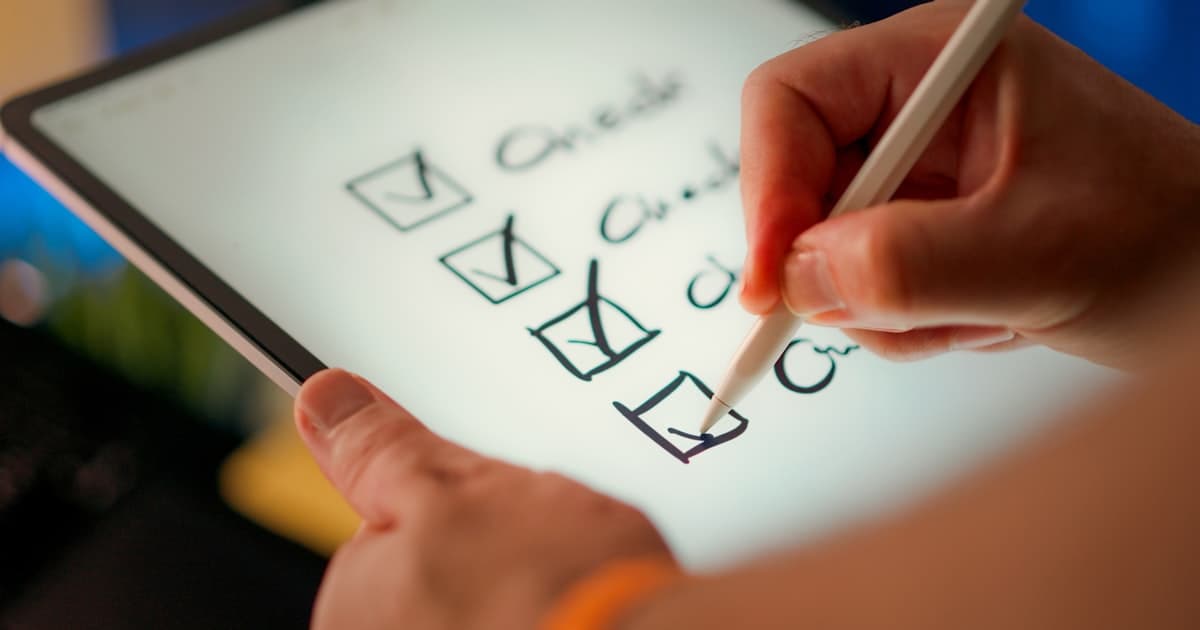 A hand ticking off items on a checklist. Most of an AI position assessment is work you can do yourself.