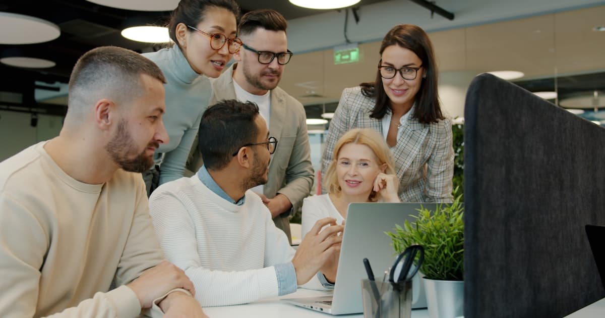 Een team rond een laptop. Het gat tussen middelgrote en grote bedrijven is eenentwintig procentpunten.