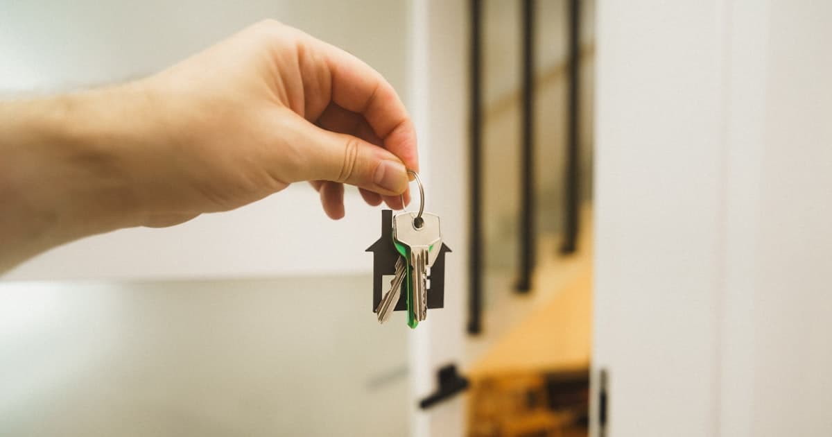 A hand holding a key to a door. The test of the work is what still runs after we leave.