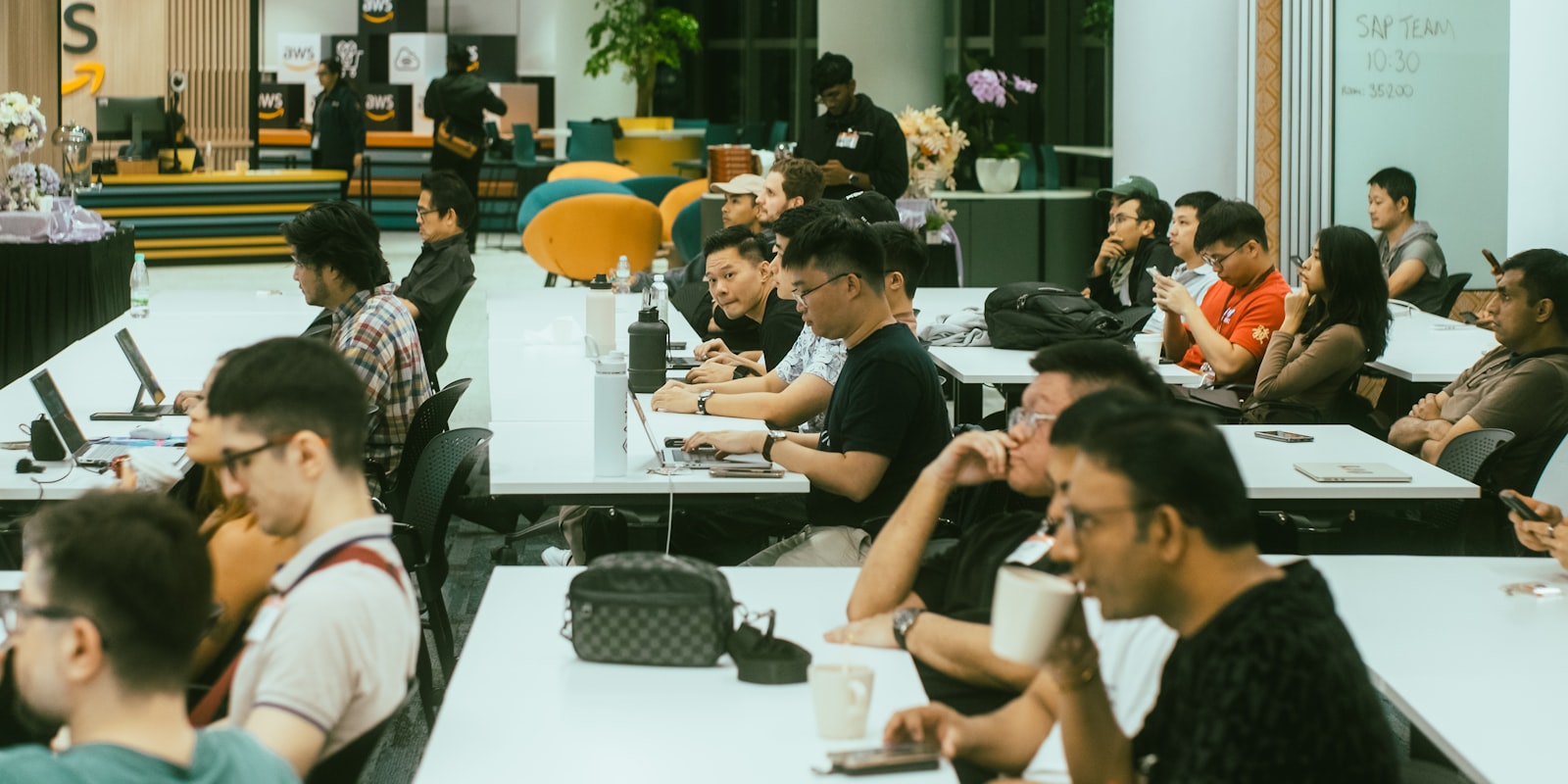 Two AI professionals working on laptops at a peer-learning session inside a community space